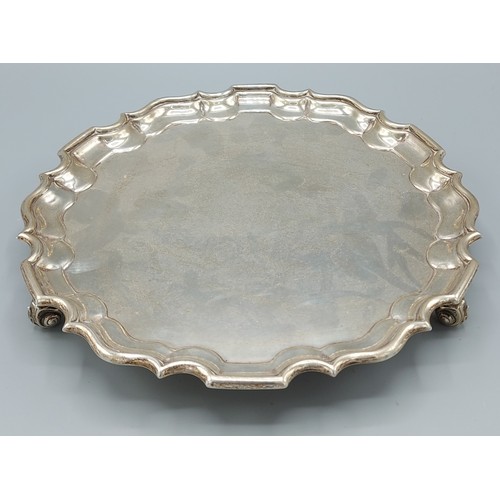 108 - A George V sliver salver of shaped outline, with three scroll feet, London 1911, 20oz, 25cms diamete... 