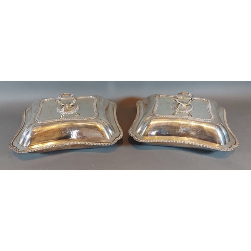 113 - A pair of white metal entrée dishes and covers with shaped embossed handles, 95ozs