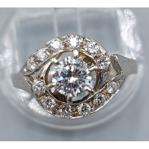 115 - An 18ct white gold diamond cluster ring, the central diamond approx. 0.50ct surrounded by smaller di... 