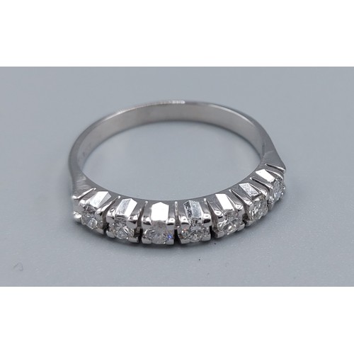 117 - A 14ct white gold diamond set band ring, set with seven diamonds within a pierced setting, ring size... 