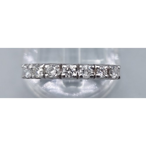 117 - A 14ct white gold diamond set band ring, set with seven diamonds within a pierced setting, ring size... 