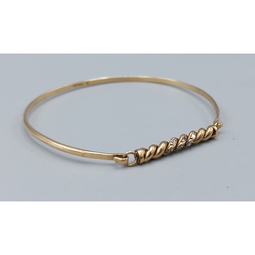 124 - A 9ct gold bangle set with two rows of diamonds, 5.2gms