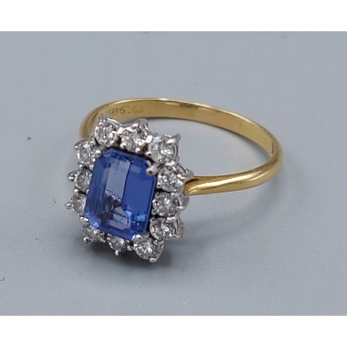 159 - An 18ct gold Tanzanite and diamond cluster ring, with a central rectangular Tanzanite surrounded by ... 