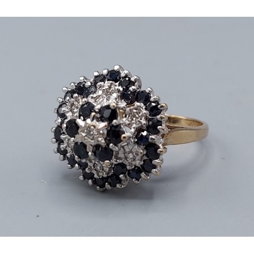 164 - A 9ct gold diamond and sapphire cluster ring of tiered form, 4.9gms, ring size K