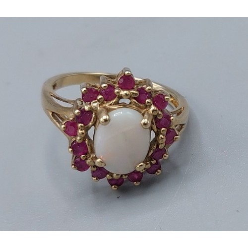 166 - A 9ct gold opal and ruby set ring, with a cabachon opal surrounded by rubies, 3.1gms, ring size M