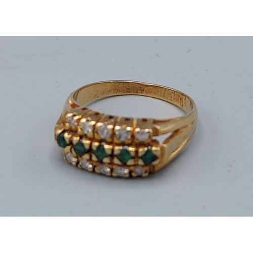 176 - A yellow metal triple band ring, set with two bands of diamonds and a central band of emeralds, 3.9g... 