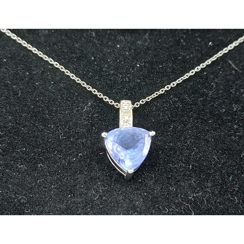 195 - An 18ct white gold Tanzanite and diamond set pendant of heart form together with a fine linked chain