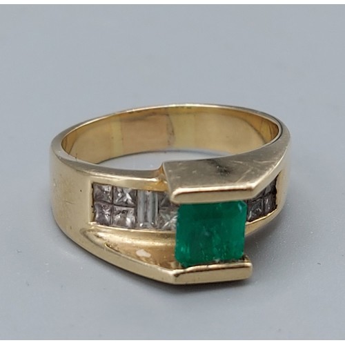 197 - A 14ct gold ring set with a square emerald mounted above a band of diamonds 8.4gms, ring size R