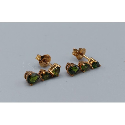 200 - A pair of 9ct gold drop earstuds, each set with three green stones