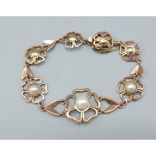 227 - A 9ct gold bracelet in the form of flower heads set with pearls, 17.5gms