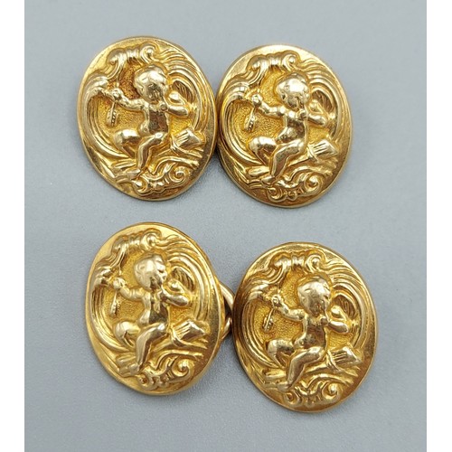 A pair of unmarked yellow gold cufflinks with embossed cherub ...