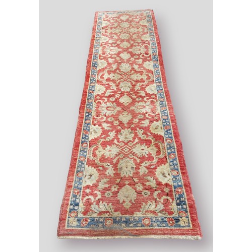 307 - A North West Persian woollen runner with all over design within multiple borders upon a blue an red ... 