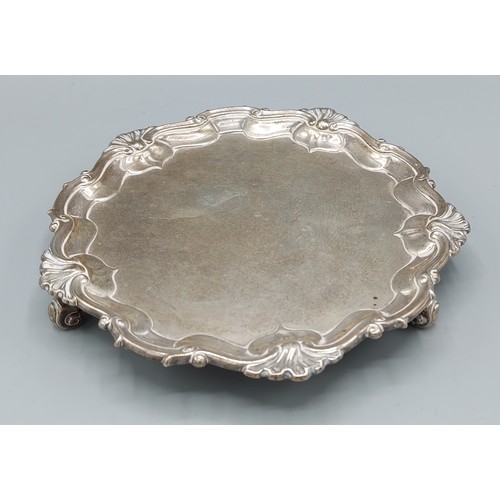 162 - A Victorian silver letter salver with shape outline raised upon three scroll feet London 1900, maker... 