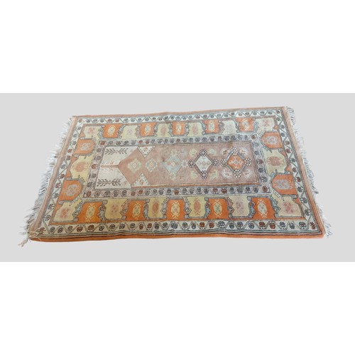 310 - COMBINED WITH LOT 309 A Turkish woollen rug with all over design upon a terracotta ground, 190cm by ... 