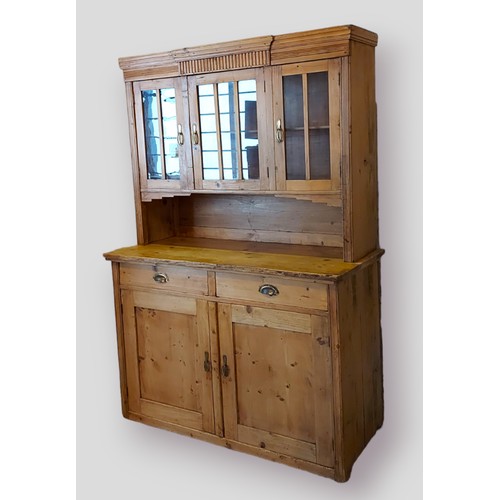 401 - A pine dresser, the top with shaped moulded cornice and three glazed doors above a moulded top with ... 