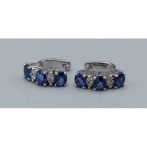 103 - A pair of 18ct white gold diamond and sapphire set earstuds, each set with three sapphire and four d... 