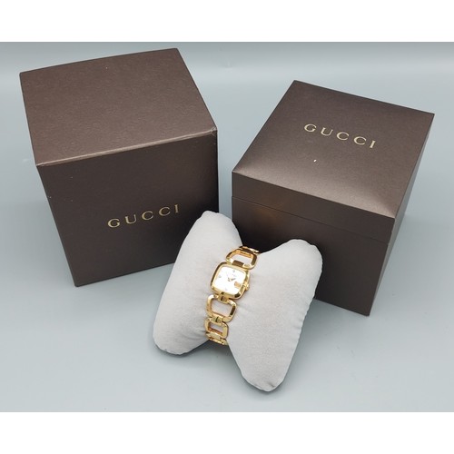 129 - A gold plated ladies wristwatch by Gucci, the M.O.P. dial set with diamond markers, complete with bo... 