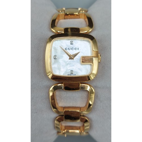 129 - A gold plated ladies wristwatch by Gucci, the M.O.P. dial set with diamond markers, complete with bo... 