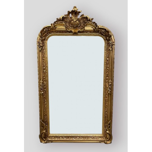 422 - A gilded over mantle mirror with shaped cresting and foliate decorated frame, 155cms by 85cms