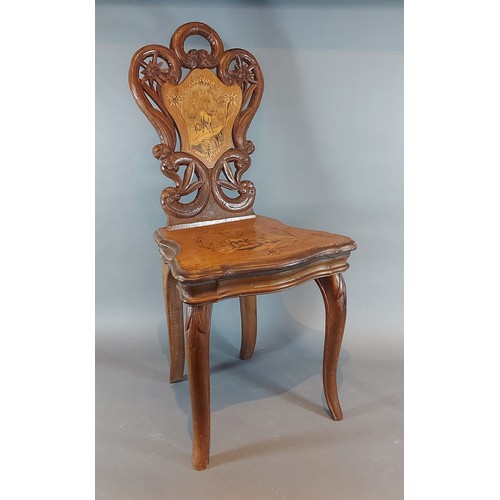 274 - A 19th Century swiss marquetry inlaid musical childs chair, with a pierced back above a moving seat ... 