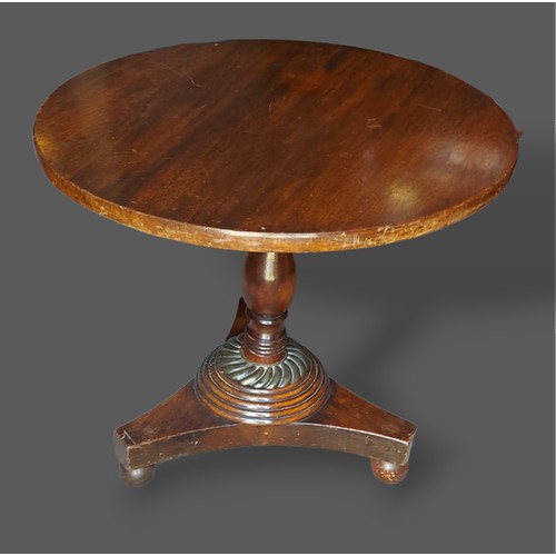 423 - A 19th Century low pedestal table, the circular top above a turned column on tri-form base