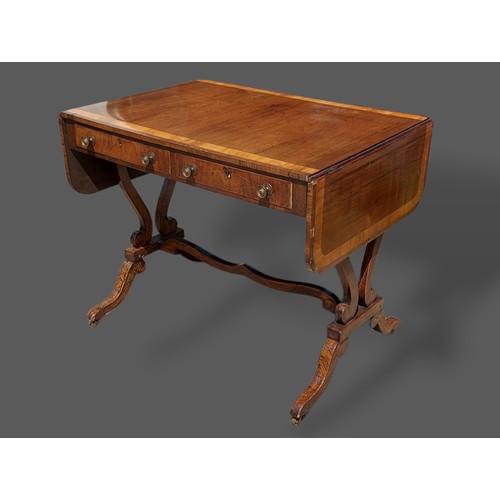 424 - A Regency sofa table, the drop flap top above two frieze drawers with outswept legs and shaped stret... 