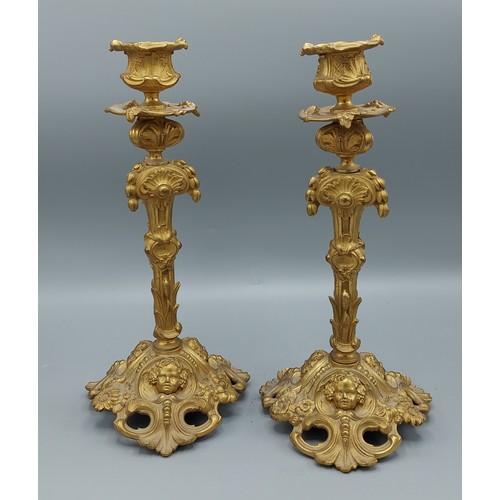 313 - A pair of ormolu candlesticks in the rococo style decorated with cherub heads amounts foliage, 27cms... 