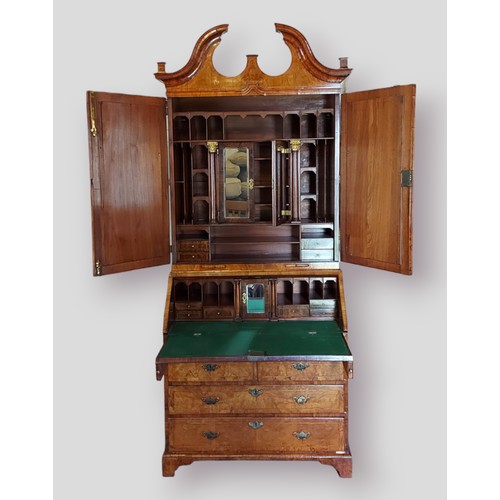 442 - A George I walnut and herringbone inlaid bureau bookcase, the swan neck pediment above two mirrored ... 