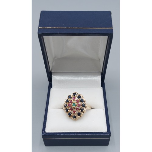 135 - A 9ct gold cluster ring set with a central Emerald surrounded by Rubies and Sapphires, 3.7gms, ring ... 