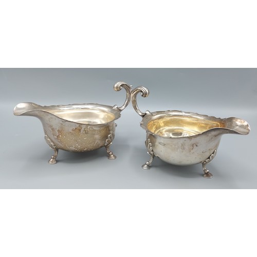 184 - A pair of Sheffield silver sauce jugs, with shaped handles and raised upon hoof supports, by Mappin ... 