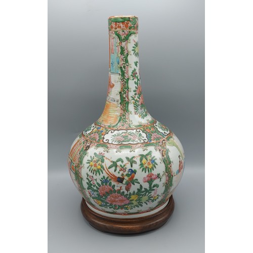 44 - A Chinese Canton bottle neck vase, decorated with figure and bird amounst foliage, upon hardwood sta... 