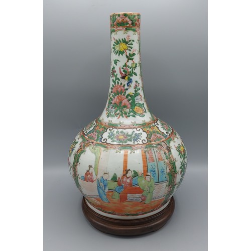 44 - A Chinese Canton bottle neck vase, decorated with figure and bird amounst foliage, upon hardwood sta... 