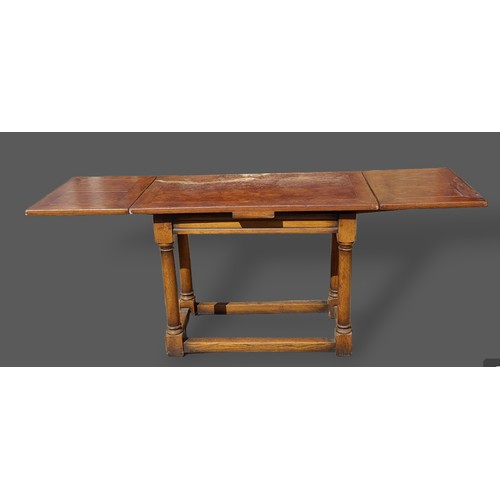 424 - An oak small refectory drawer leaf dining table with a moulded frieze raised upon turned legs with s... 