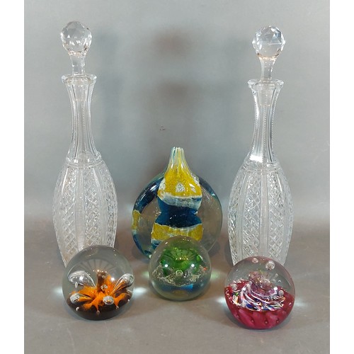 14 - A pair of cut glass decanters with stoppers together with four glass paperweights