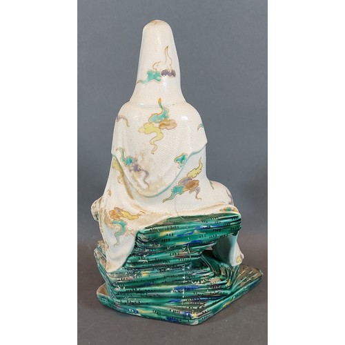 16 - A Chinese porcelain figure in the form of Guan Yin holding a scroll upon green glazed rocky base, 27... 