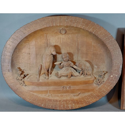 250 - A Black Forest carved oval panel depicting a child with two dogs, 48cms X 62cms together with anothe... 