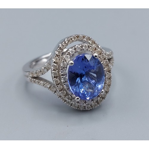 134 - COLLECTED  A 14ct white gold ring set with a Tanzanite surrounded by diamonds in a tiered form, diam... 