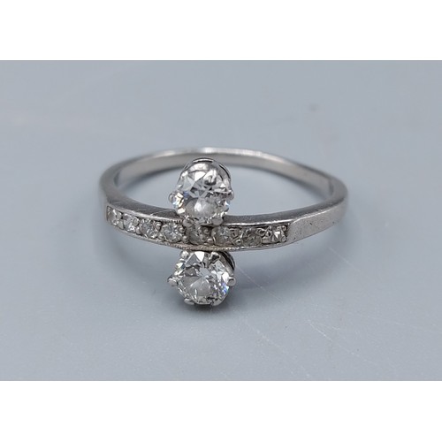 153 - A two stone diamond ring, the two diamonds claw set flanking a band of smaller diamonds, 3.2gms, rin... 