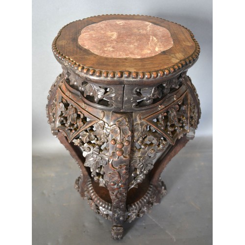 366 - A Chinese Hardwood Vase Stand, the shaped rouge marble inset top above a pierced carved frieze raise... 