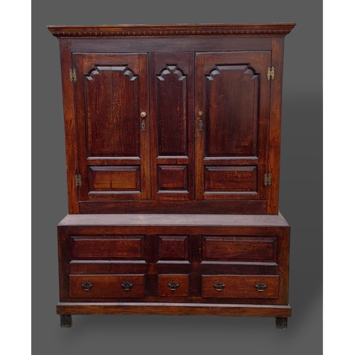 368 - A george III oak Bacon cupboard, the moulded cornice above two panel doors, the lower section with t... 