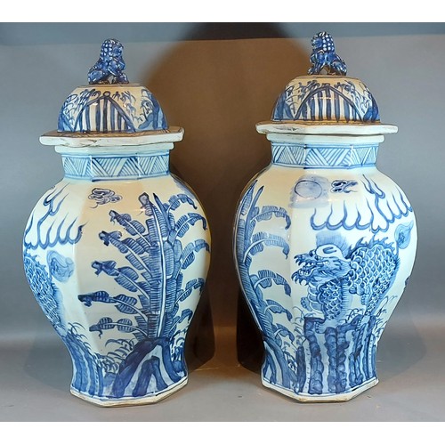 66 - A pair of Chinese large under glaze blue decorated covered vases of octagonal form, decorated with s... 