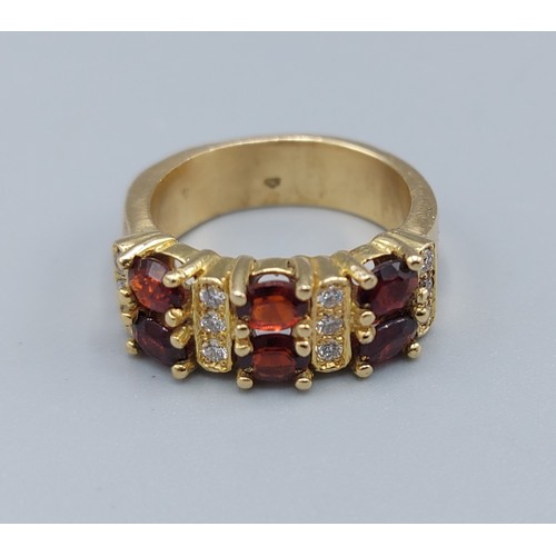 182 - An 18ct gold Garnet and Diamond ring, set with six Garnets intersperse with diamonds, ring size J, 8... 