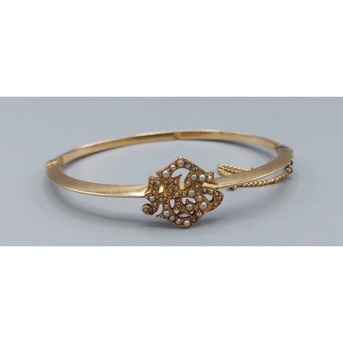 193 - A yellow metal bangle with pearl decoration, 4.5cms by 6cms, 7.7gms