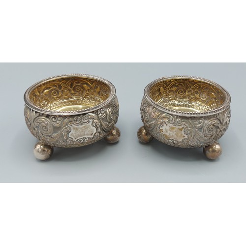 197 - A pair of Victorian silver salts, with embossed decoration raised upon low feet, London 1883, 3ozs