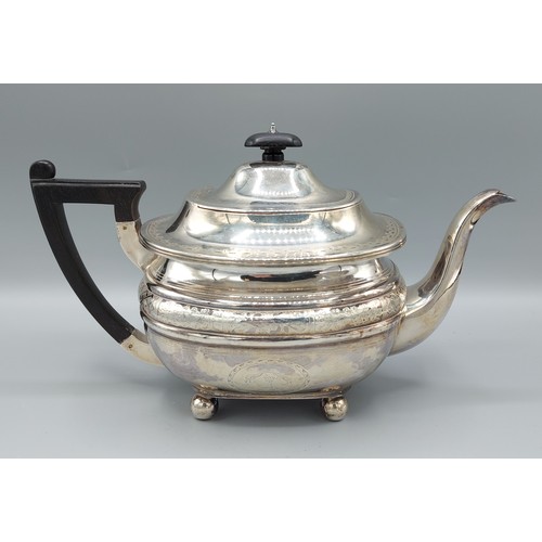 92 - A Victorian silver teapot with engraved decoration, ebonised handle and four ball feet, London 1890,... 