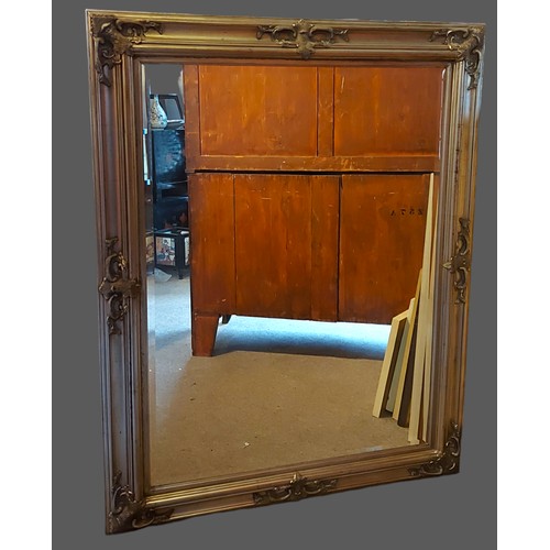 237 - A large rectangular silvered wall mirror with bevelled edge plate, the frame with applied decoration... 