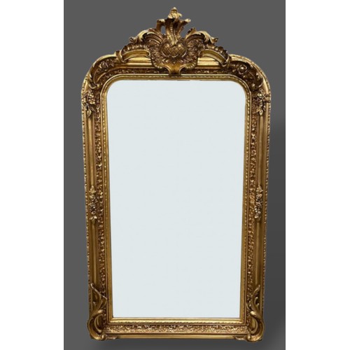 273 - A gilded over mantle mirror with shaped cresting and foliate decorated frame, 155cms by 85cms