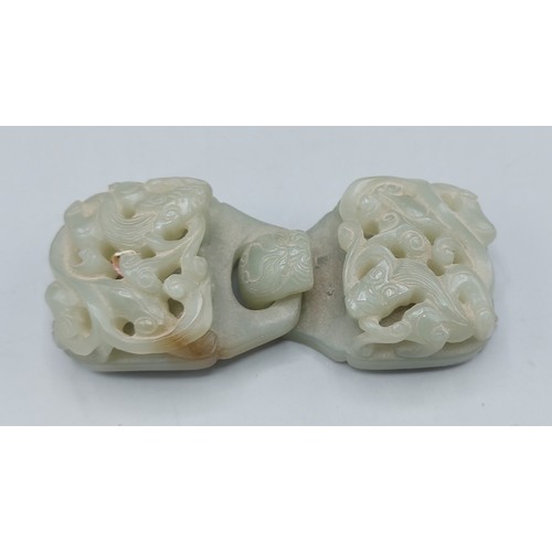 218 - A Chinese Jade belt buckle of carved pierced form, 10.5cms long