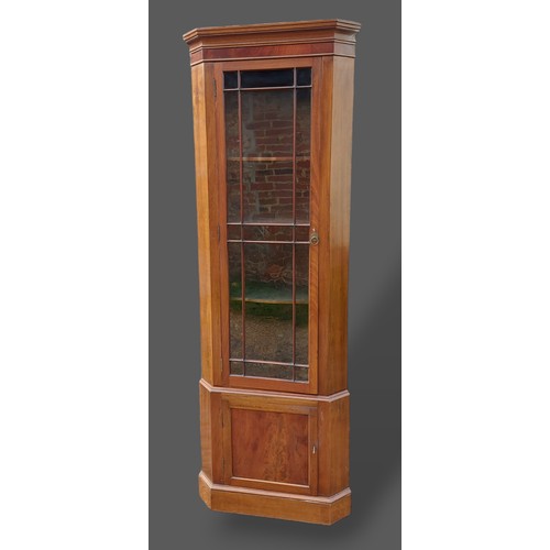 365 - A mahogany standing corner cupboard, the moulded cornice above an astragal glaze door and raised upo... 