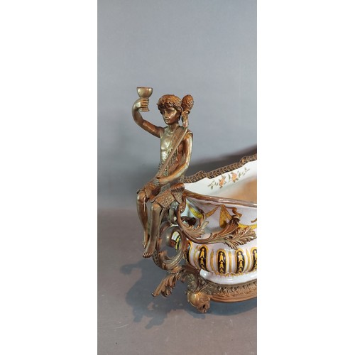 39 - A French oval jardiniere with gilt metal figural surmounts decorated in polychrome enamels, 66cms lo... 